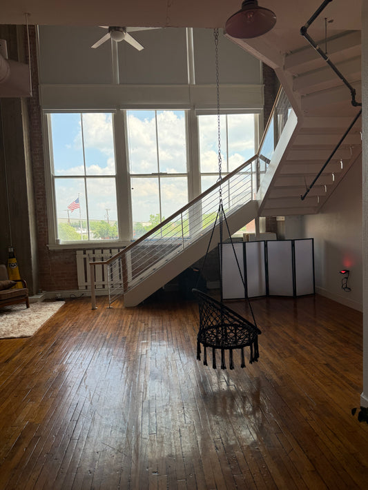 Modern interior with wooden floor, staircase, and large windows.