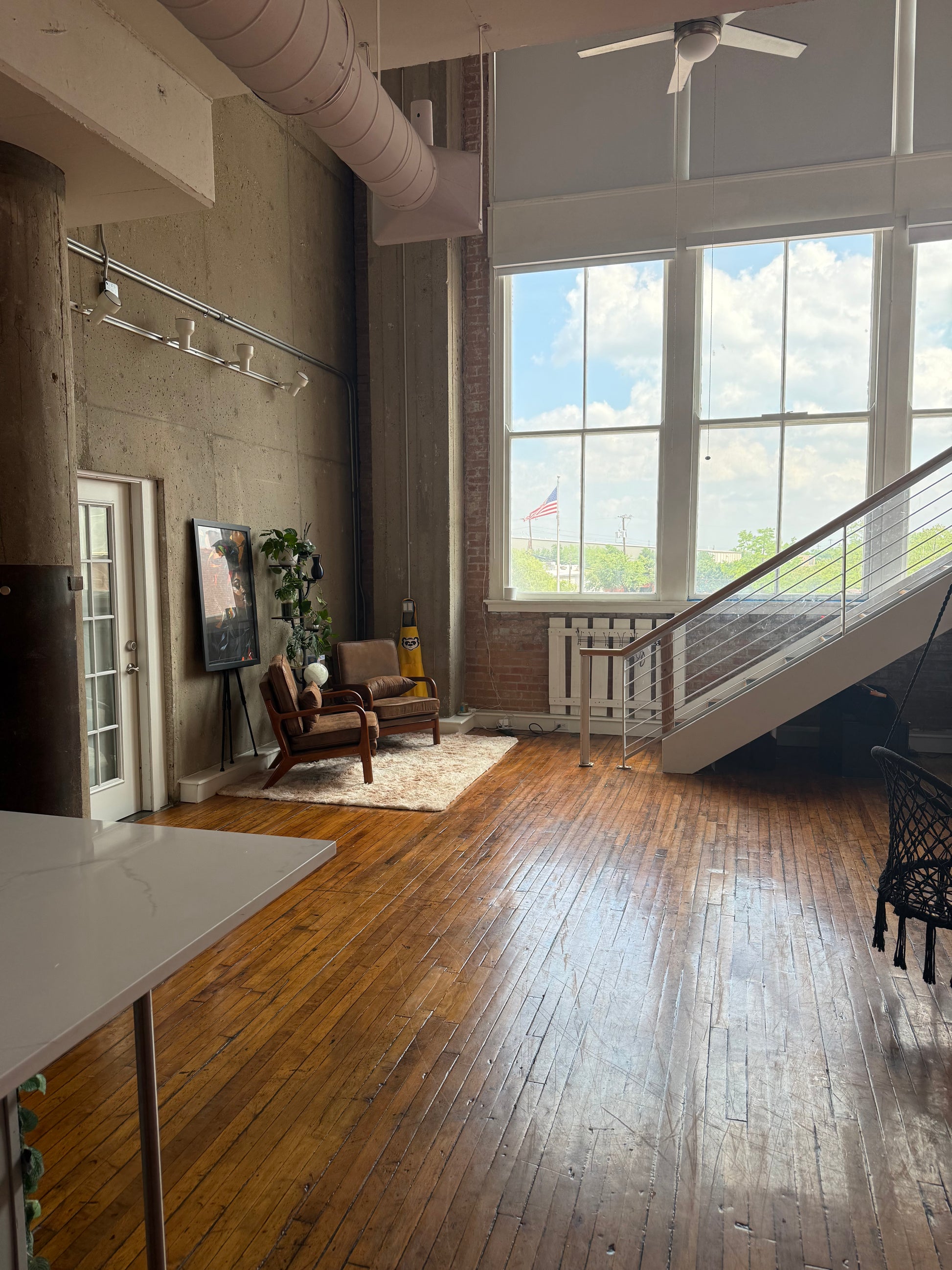 Modern interior with wooden floor, large windows, and staircase