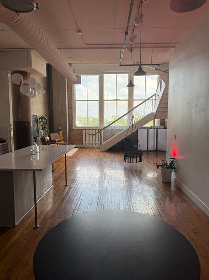 Modern interior with large windows, wooden floor, and staircase